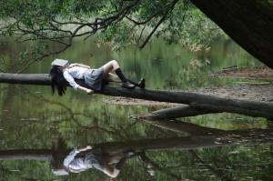 woman lying on tree near awter